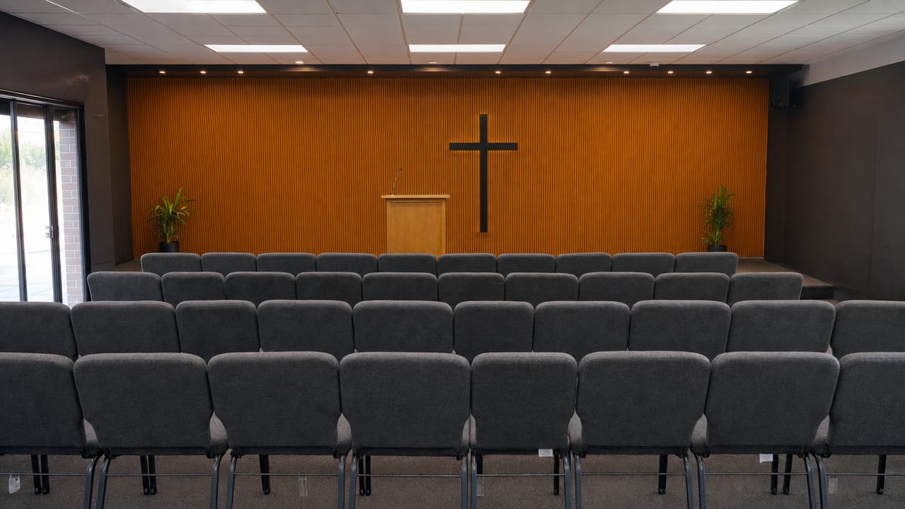 An empty church auditorium with a single microphone stand